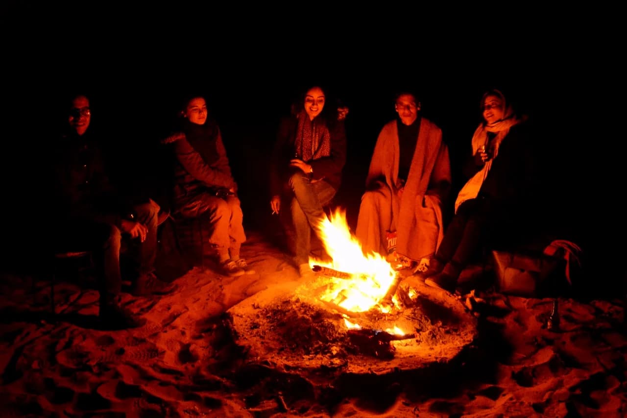 Morocco desert tours — friends around a campfire at a luxury Sahara desert camp